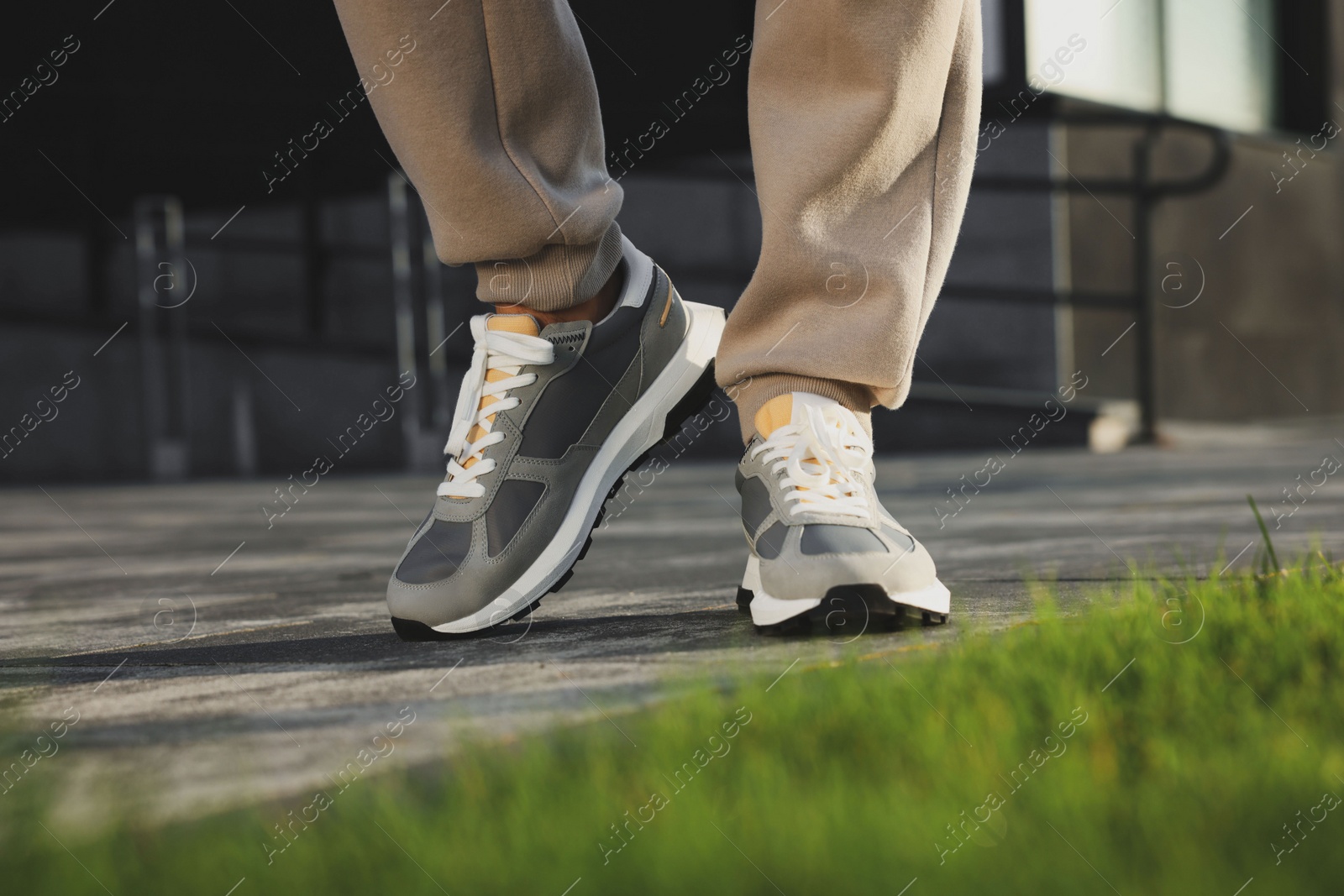 Photo of Man wearing pair of stylish sneakers outdoors, closeup