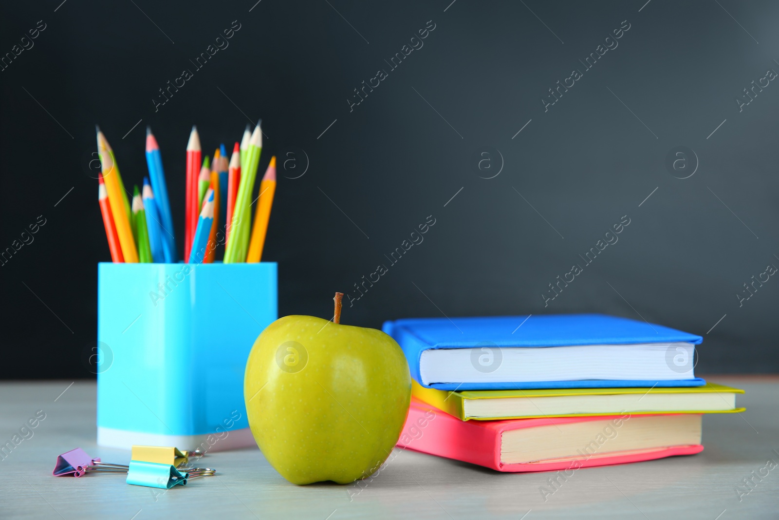 Photo of Apple and school stationery on white wooden table. Doing homework