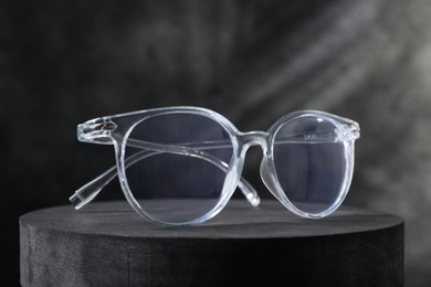 Photo of Stylish presentation of glasses on dark background, closeup