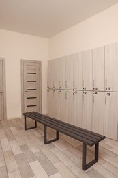 Photo of Wooden bench and lockers in changing room interior