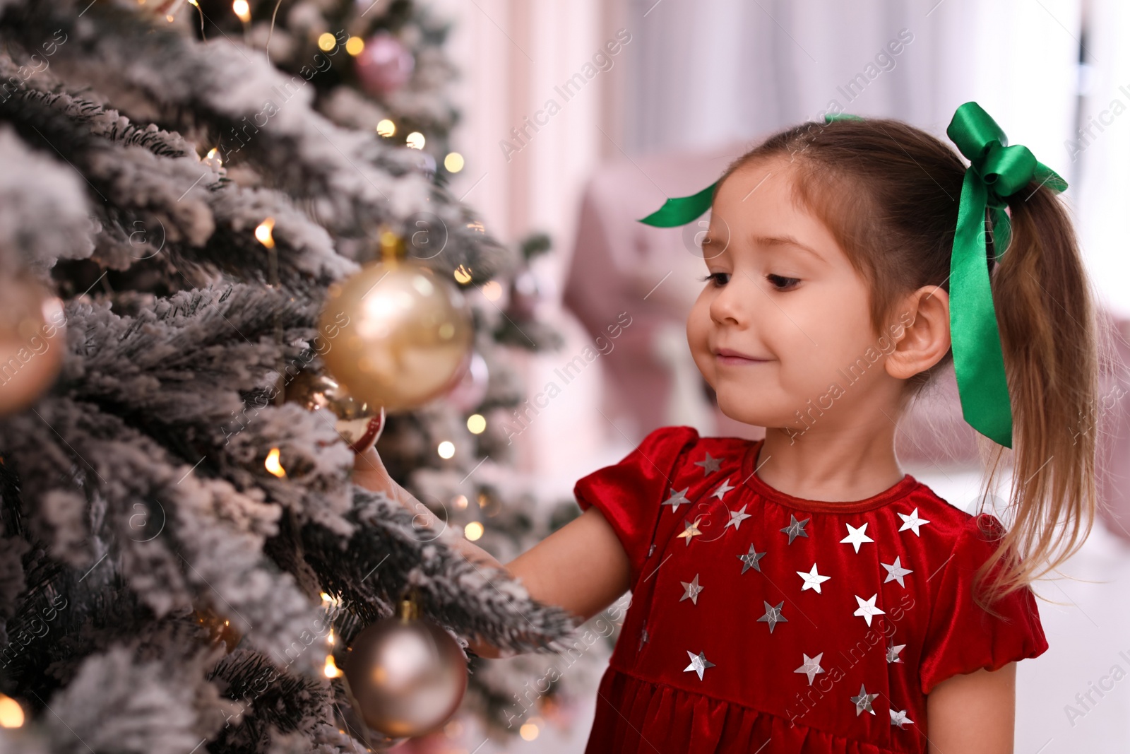 Photo of Cute little child near Christmas tree at home