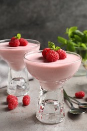 Photo of Delicious raspberry mousse with mint on light grey table