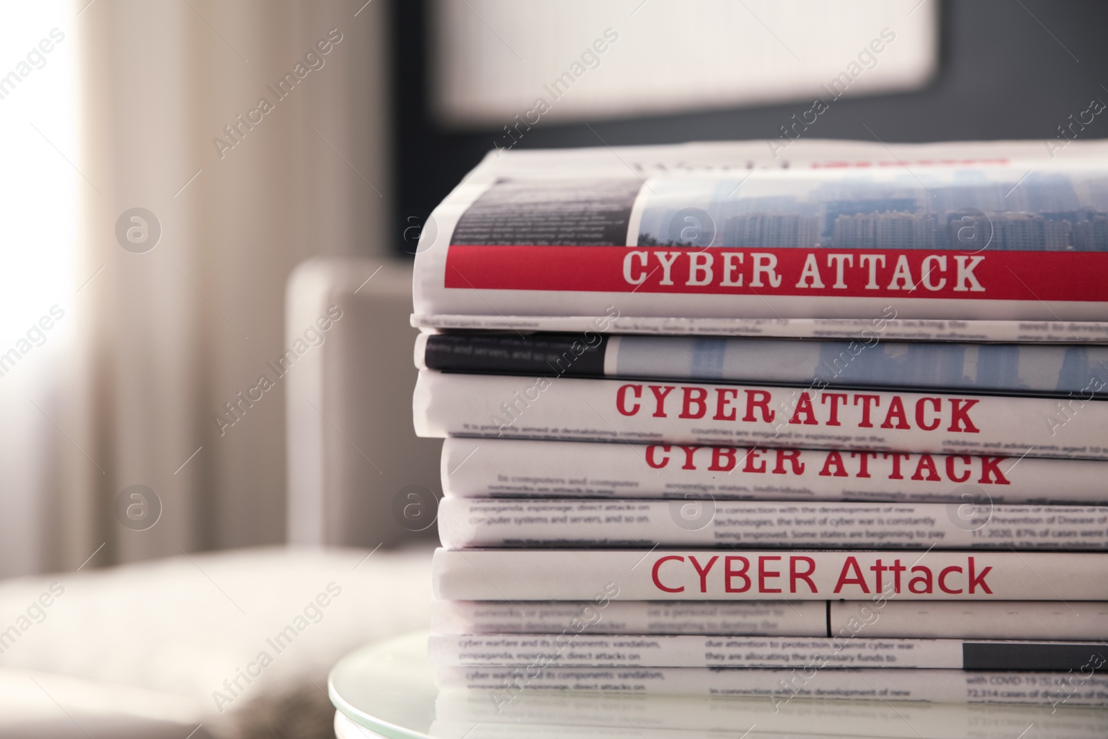 Photo of Stack of newspapers with headlines CYBER ATTACK on table indoors, closeup