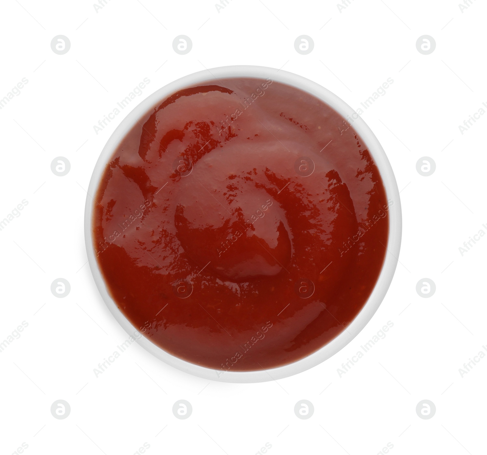 Photo of Tasty ketchup in bowl isolated on white, top view