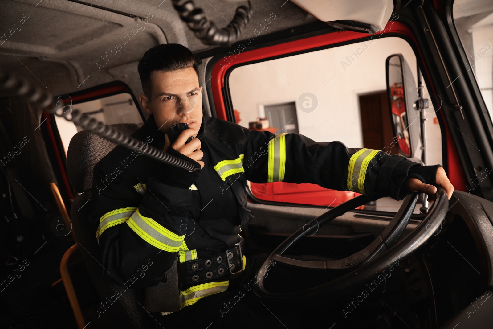 Photo of Firefighter using radio set while driving fire truck