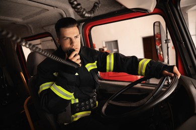 Firefighter using radio set while driving fire truck