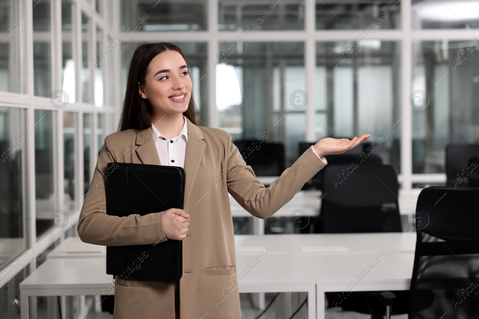 Photo of Happy real estate agent with leather portfolio in office