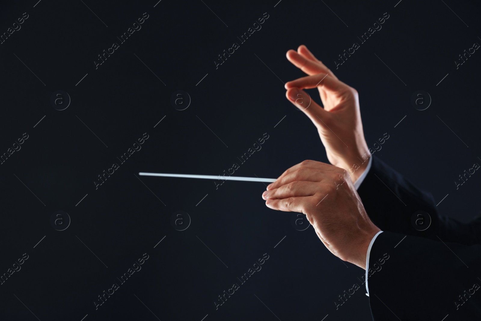 Photo of Professional conductor with baton on black background, closeup. Space for text