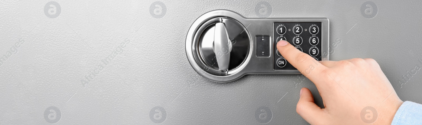 Image of Man opening steel safe with electronic combination lock, closeup. Banner design