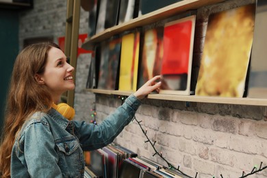 Image of Young woman choosing vinyl records in store