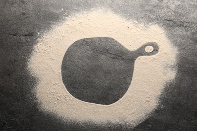 Photo of Imprint of board on grey textured table with flour, top view