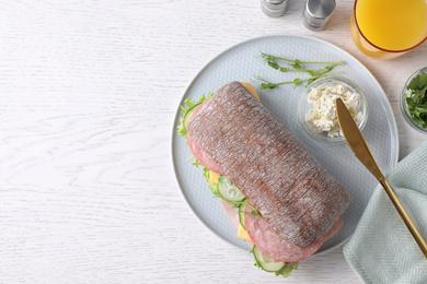 Photo of Tasty sandwich with ham served on white wooden table, flat lay. Space for text