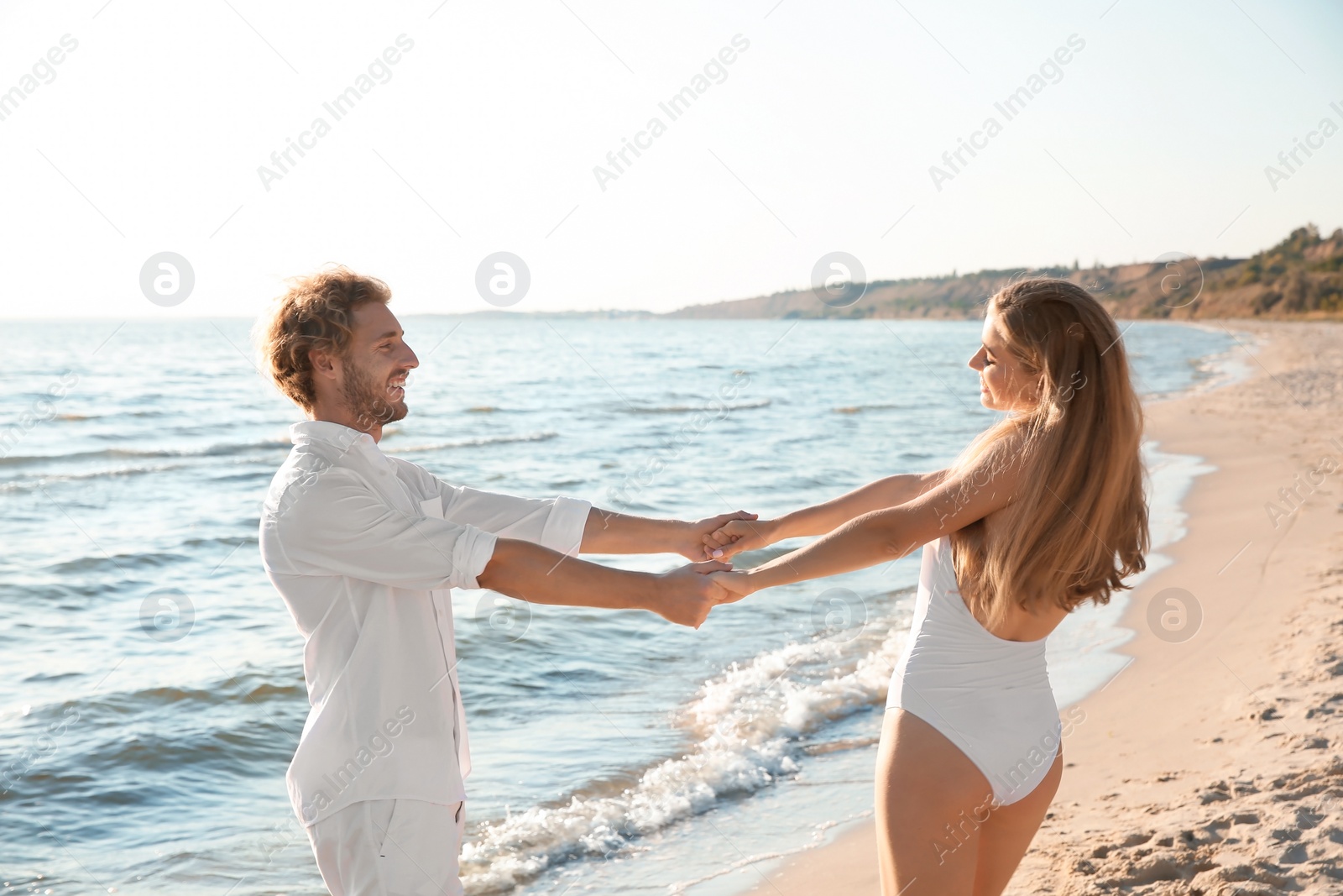 Photo of Romantic young couple dancing together on beach