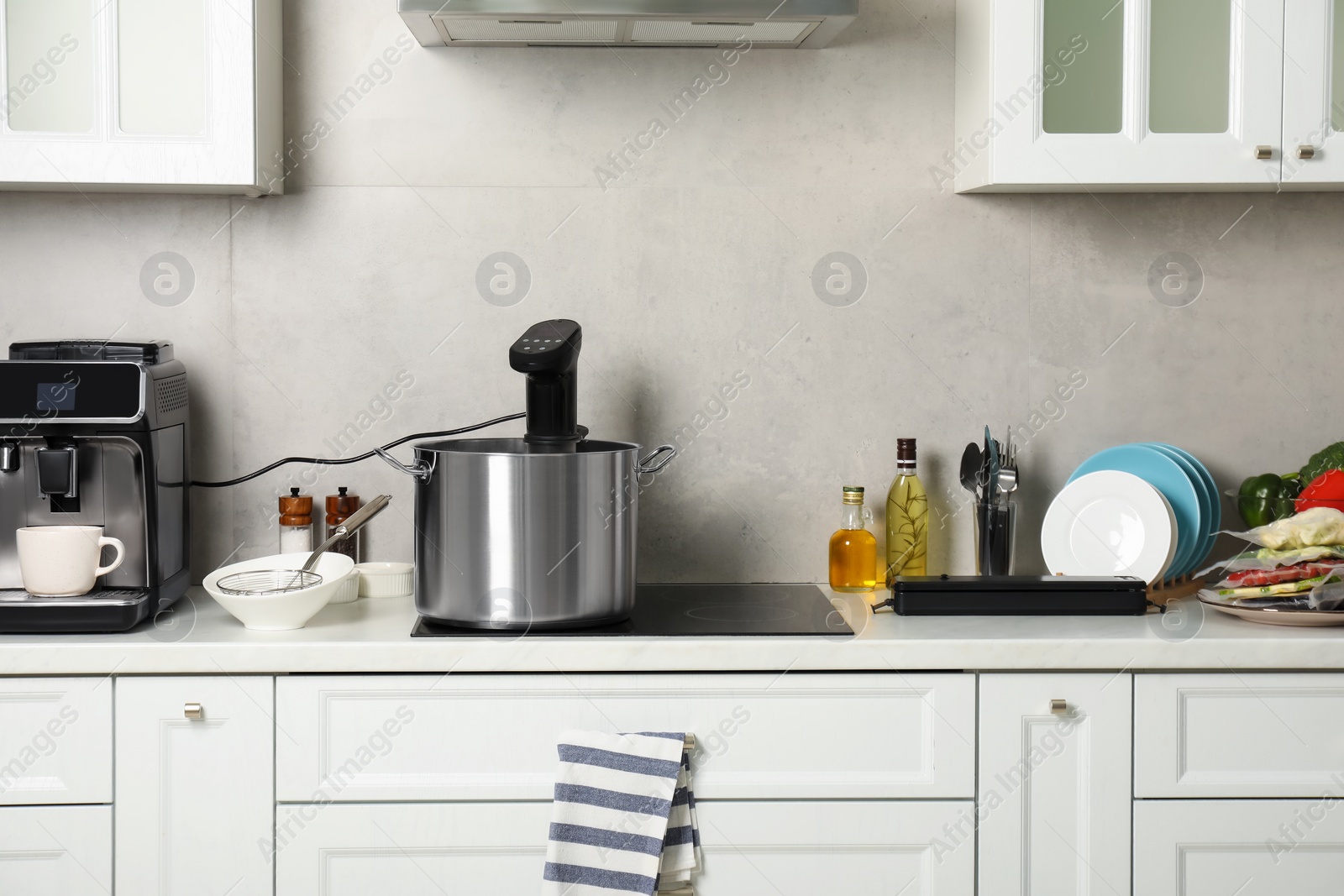 Photo of Pot with sous vide cooker in kitchen. Thermal immersion circulator