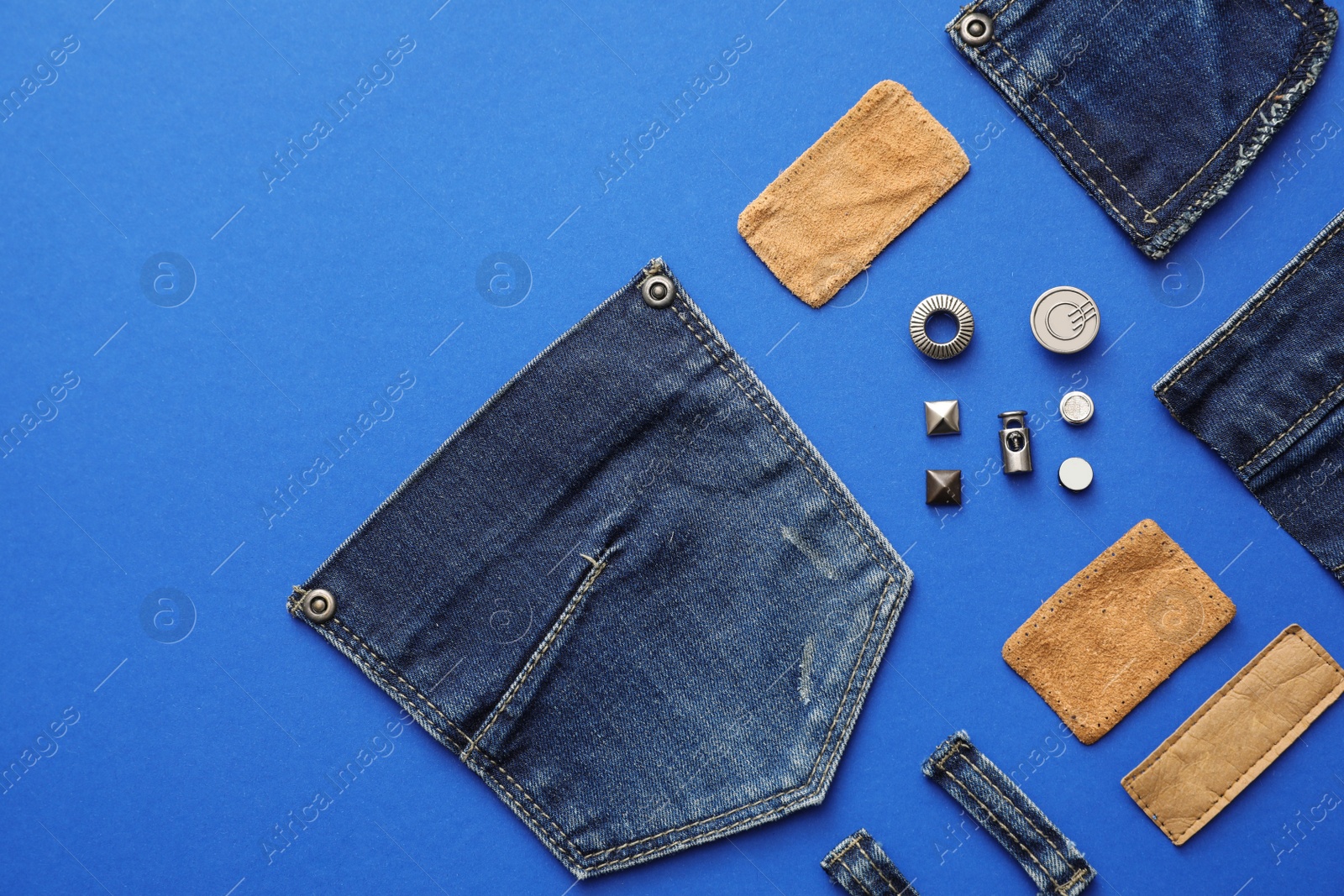 Photo of Flat lay composition with garment accessories and cutting details for jeans on blue background