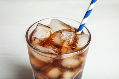 Photo of Glass of refreshing soda drink with ice cubes and straw on white background, closeup