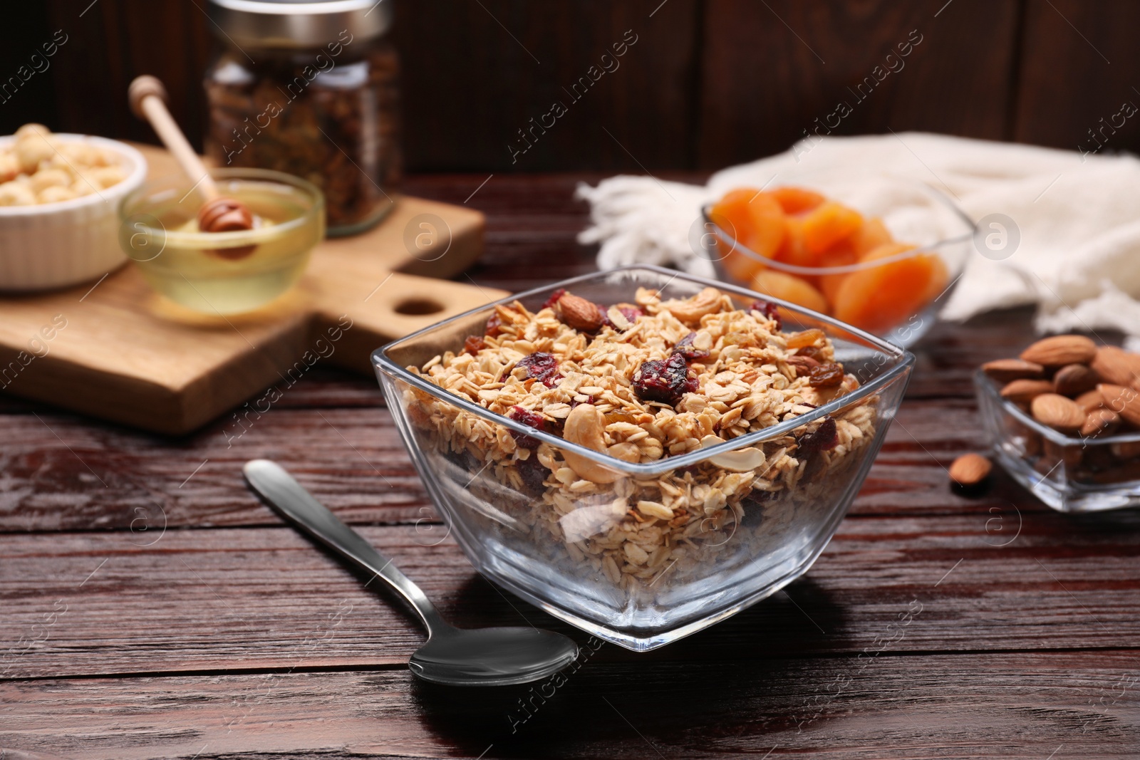 Photo of Tasty granola served with nuts and dry fruits on wooden table