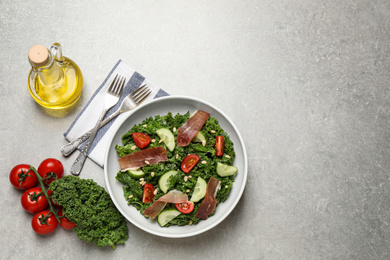 Photo of Delicious kale salad on light grey table, flat lay. Space for text