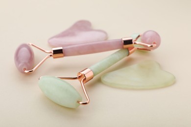 Photo of Gua sha tools and facial rollers on beige background