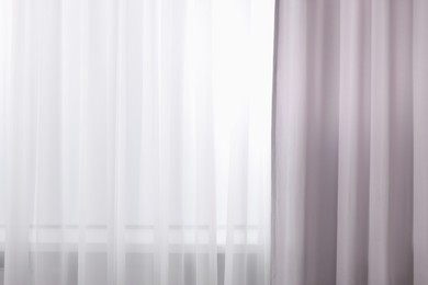 Photo of Light grey window curtains and white tulle indoors, closeup