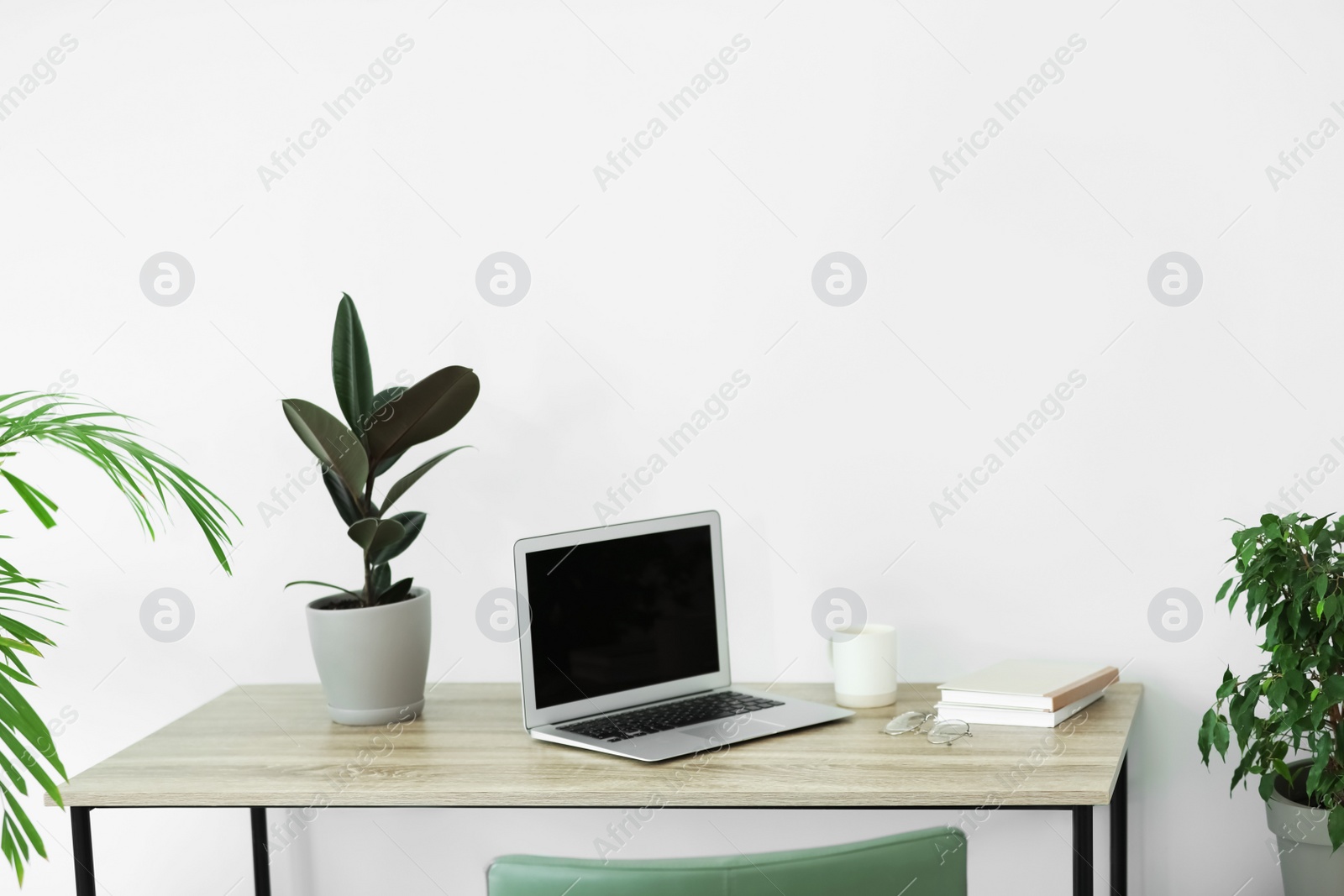 Photo of Comfortable workplace with modern laptop on wooden table in room. Interior design