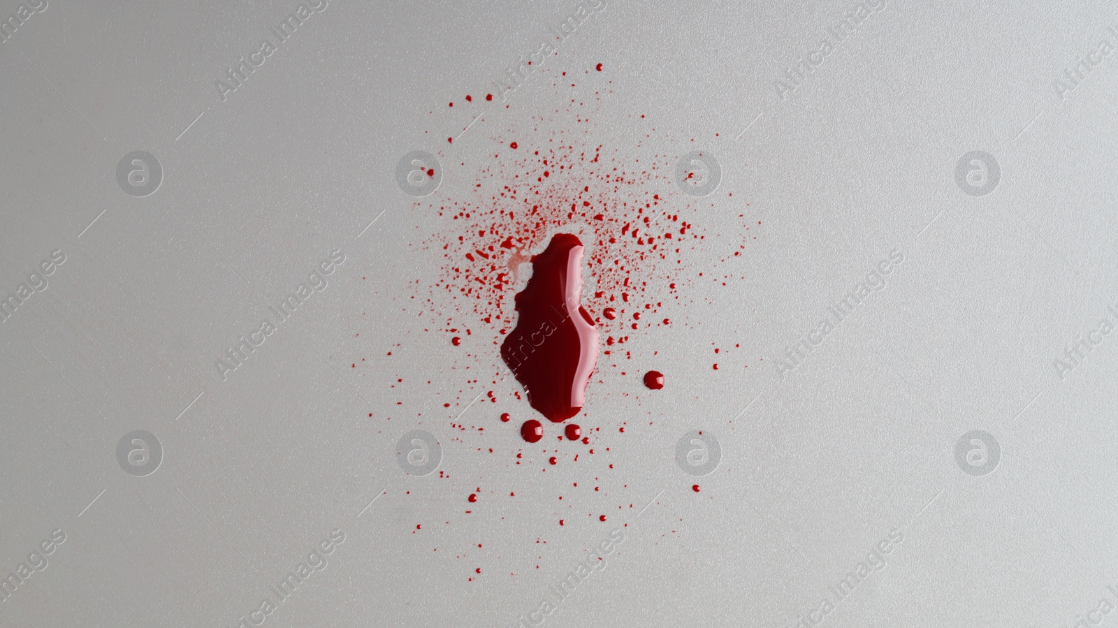 Photo of Stain and splashes of blood on light grey background, top view