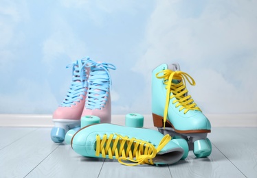 Vintage roller skates on floor near color wall