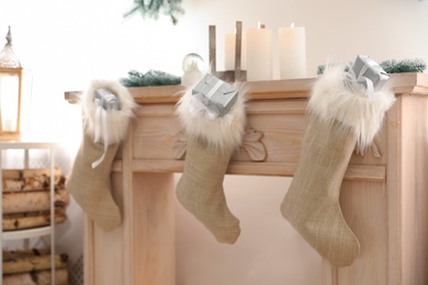 Photo of Fireplace decorated with Santa stockings indoors. Christmas decor idea