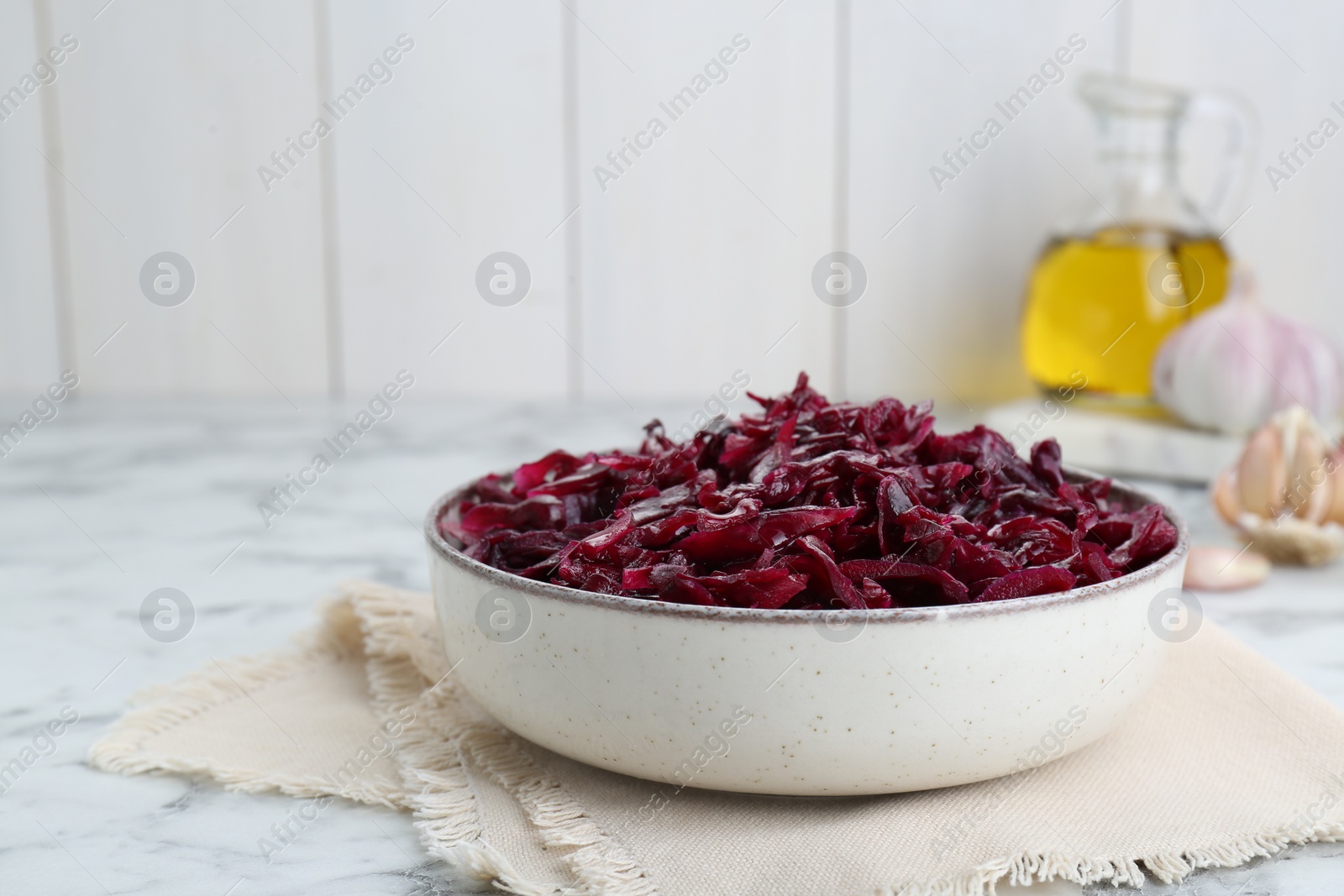 Photo of Tasty red cabbage sauerkraut on white marble table. Space for text