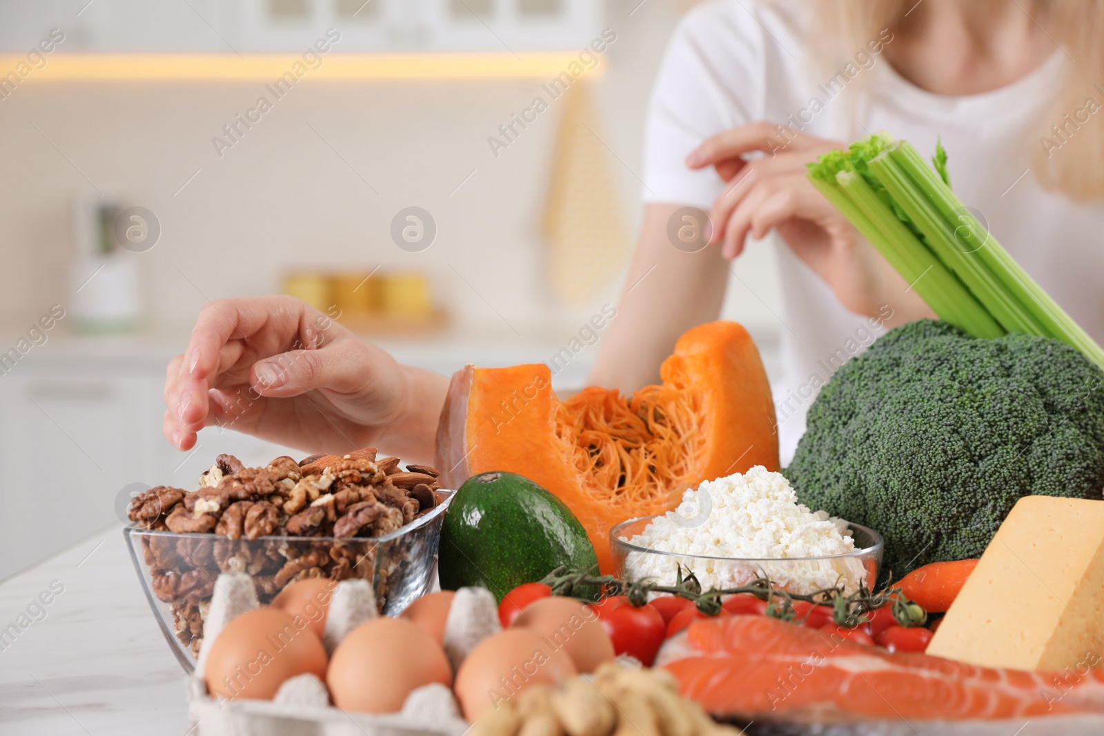 Photo of Woman and healthy food at white table, closeup. Keto diet