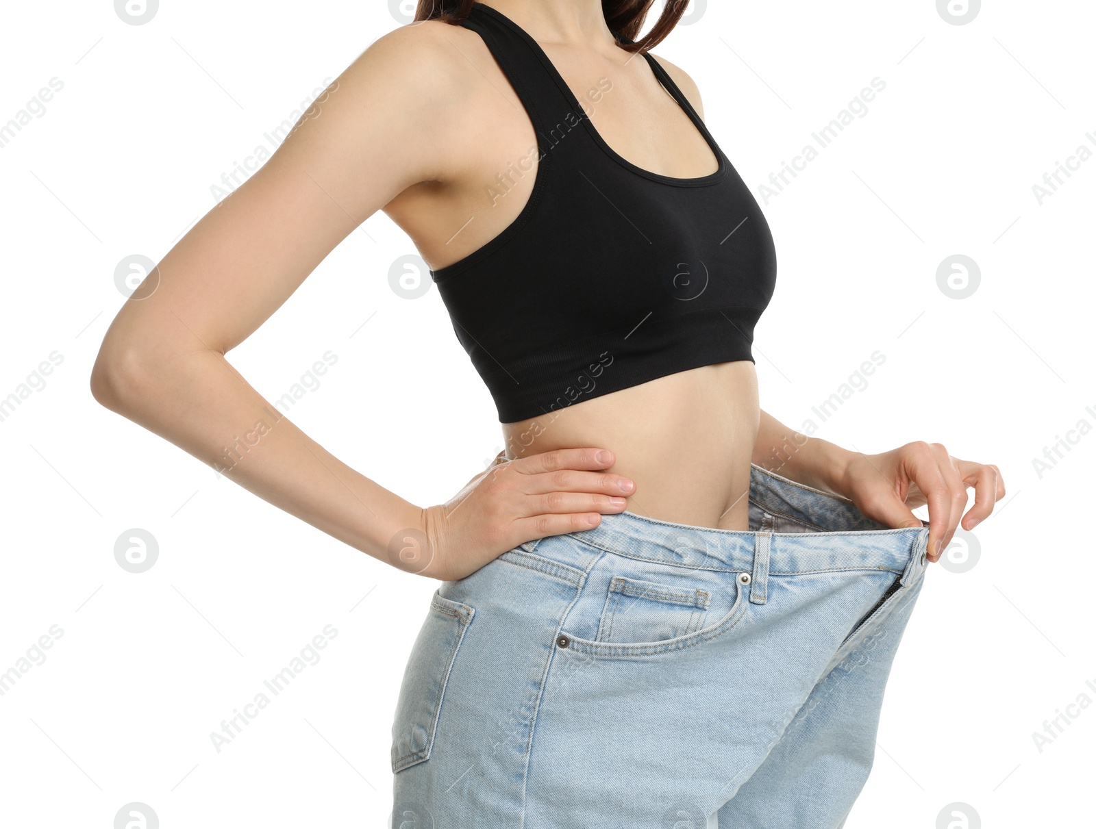 Photo of Woman in big jeans showing her slim body on white background, closeup