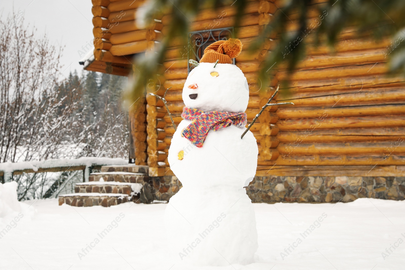 Photo of Funny snowman with hat and scarf outdoors. Winter vacation