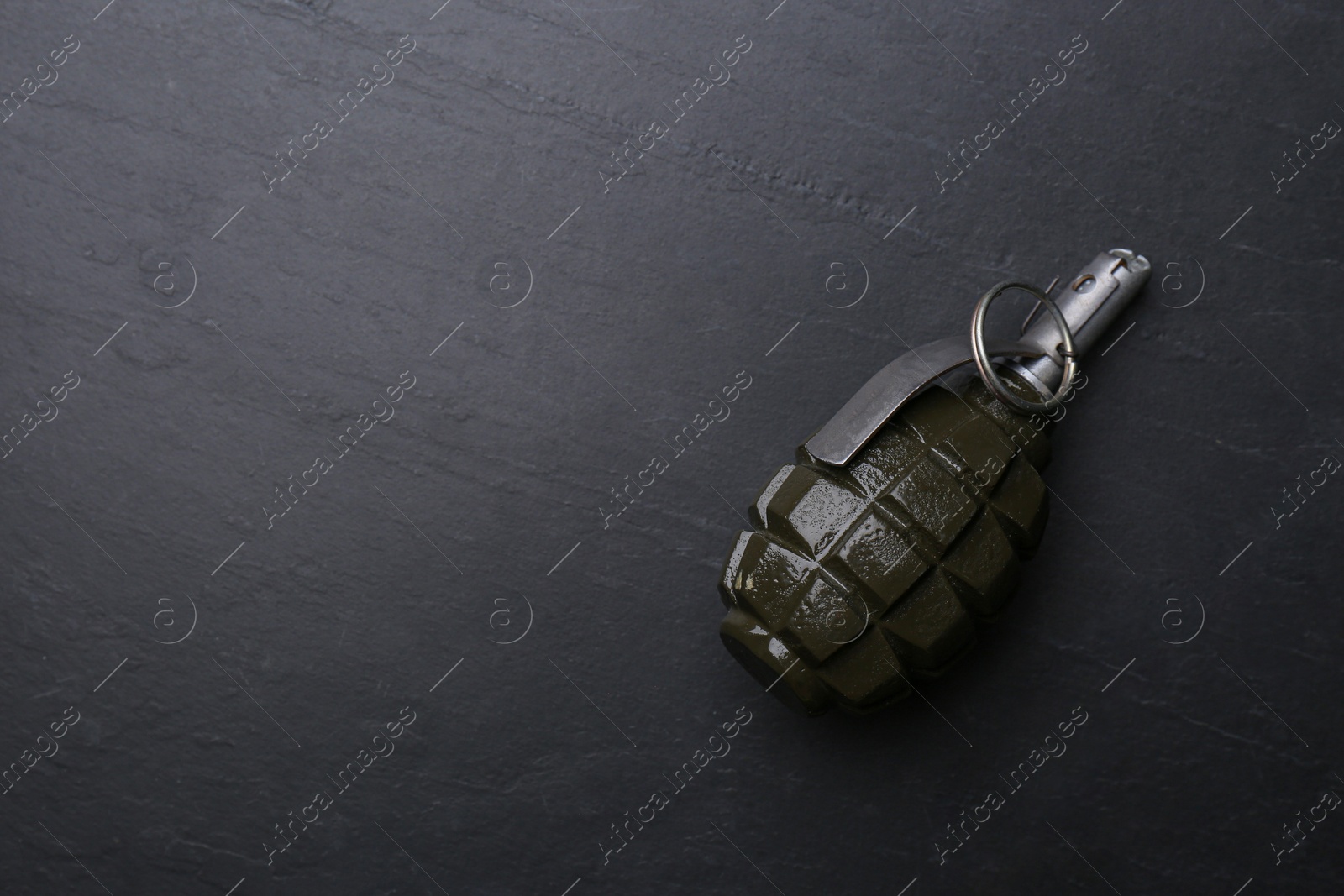 Photo of Hand grenade on black background, top view. Space for text