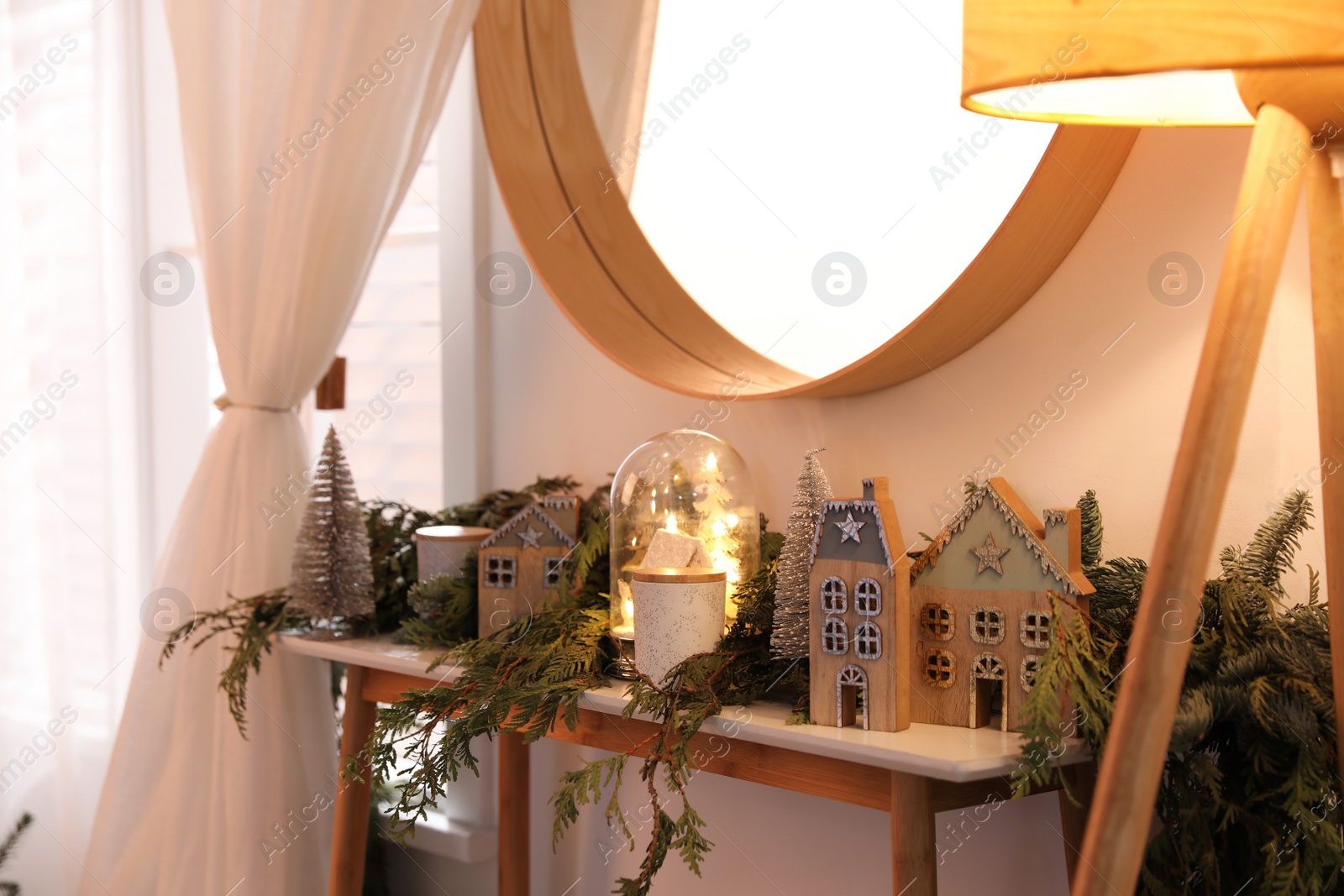 Photo of Wooden console table with Christmas decor near wall in room. Interior design