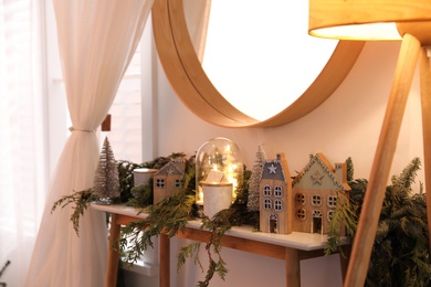 Wooden console table with Christmas decor near wall in room. Interior design