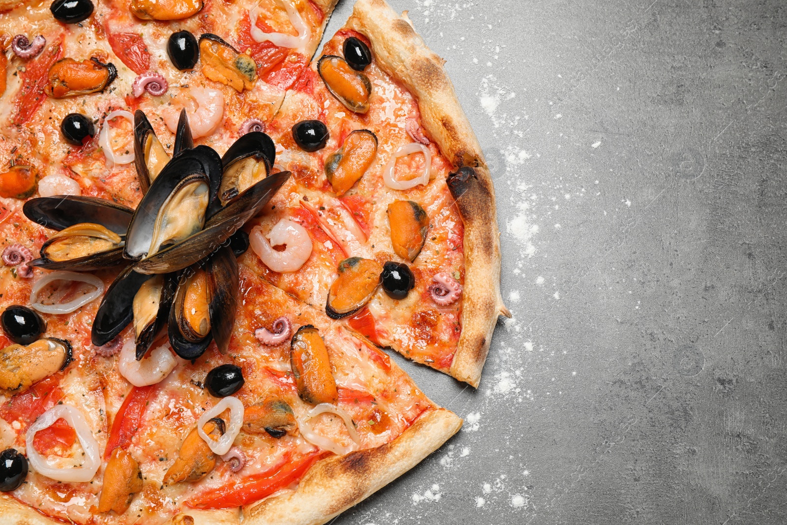 Photo of Tasty pizza with seafood on grey table, top view. Space for text