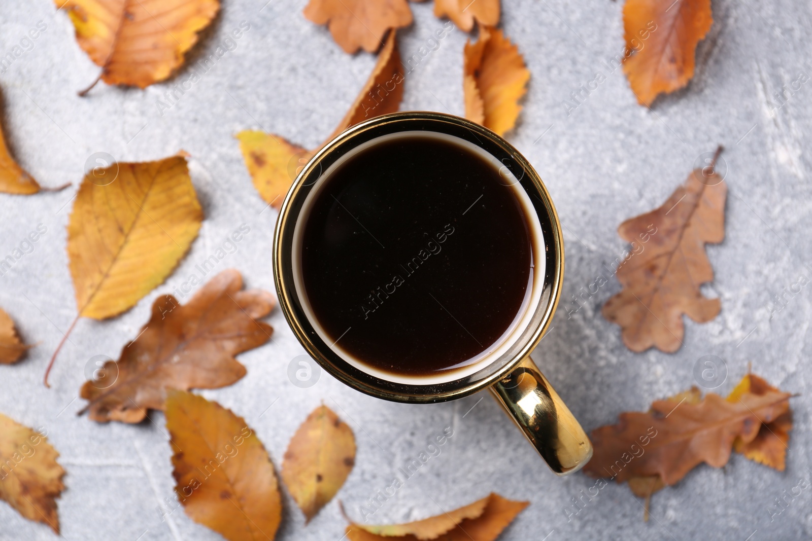 Photo of Flat lay composition with cup of hot drink and autumn leaves on light grey textured table