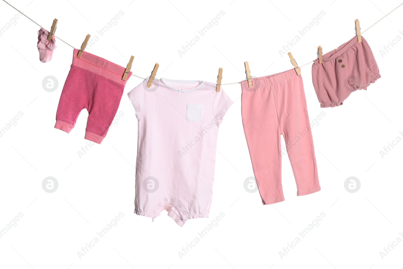 Photo of Different baby clothes drying on laundry line against white background