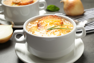 Photo of Tasty homemade french onion soup served on grey table, closeup