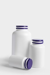 Photo of Closed plastic medicine bottles on white background. Medicament