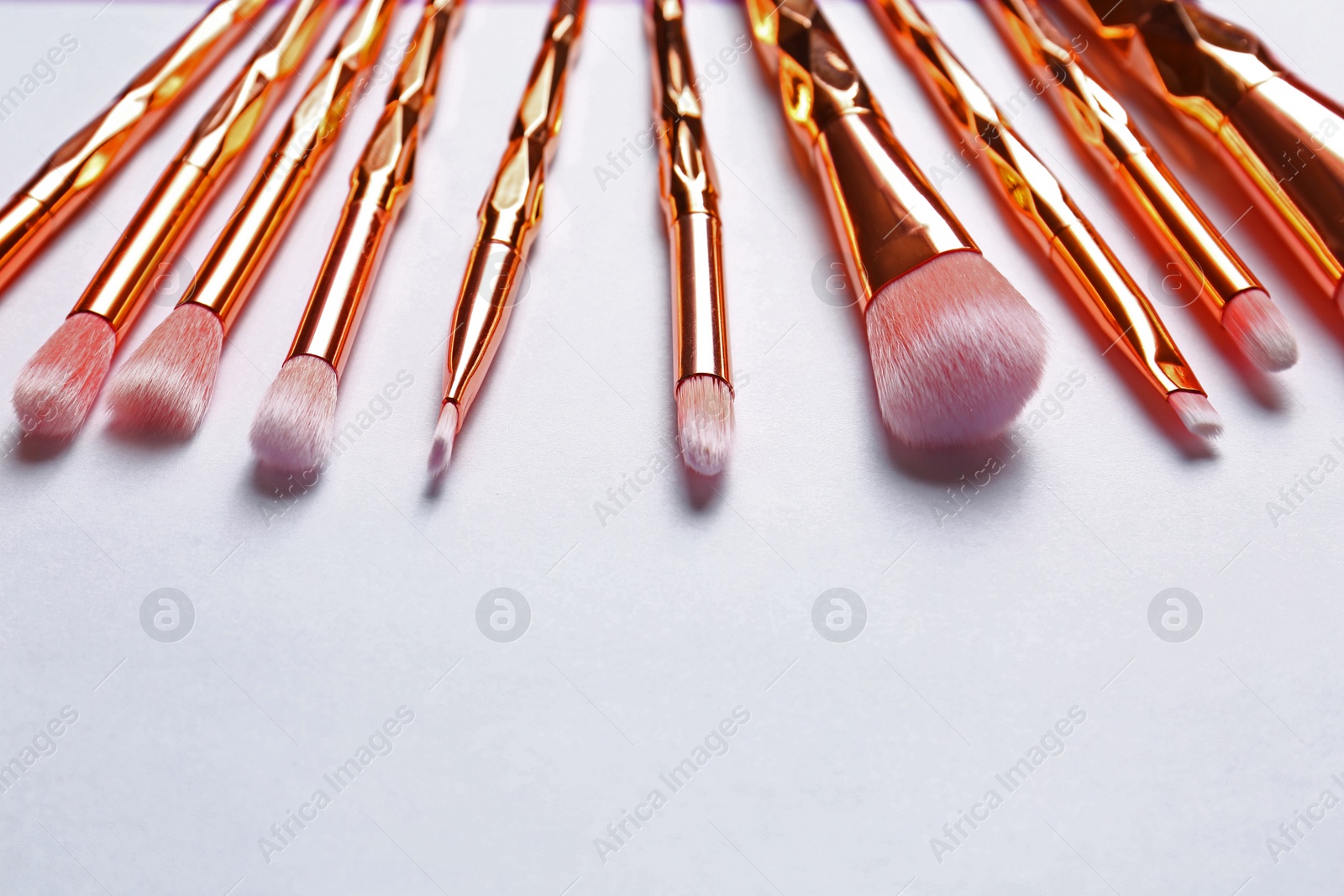 Photo of Many different makeup brushes on light lilac background, space for text