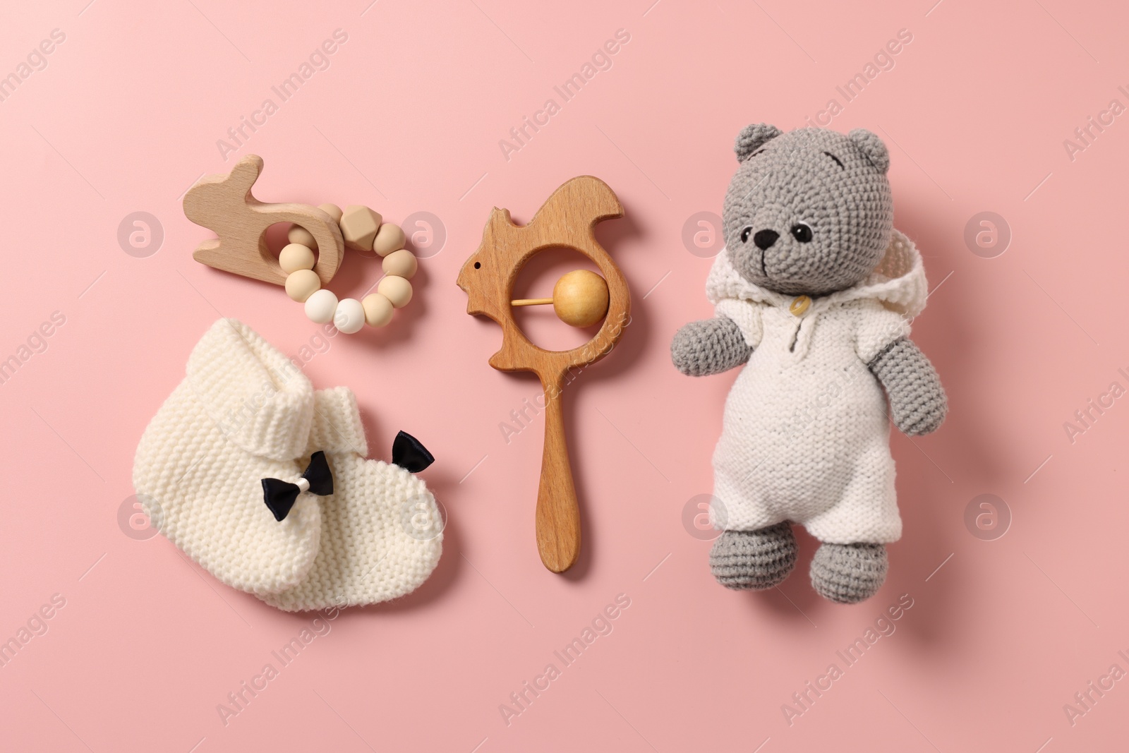 Photo of Baby accessories. Different toys and booties on pink background, flat lay