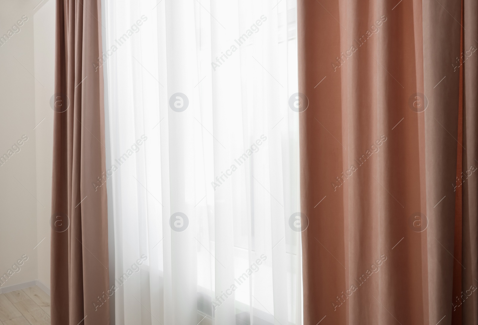 Photo of Elegant window curtains and white tulle indoors. Interior design