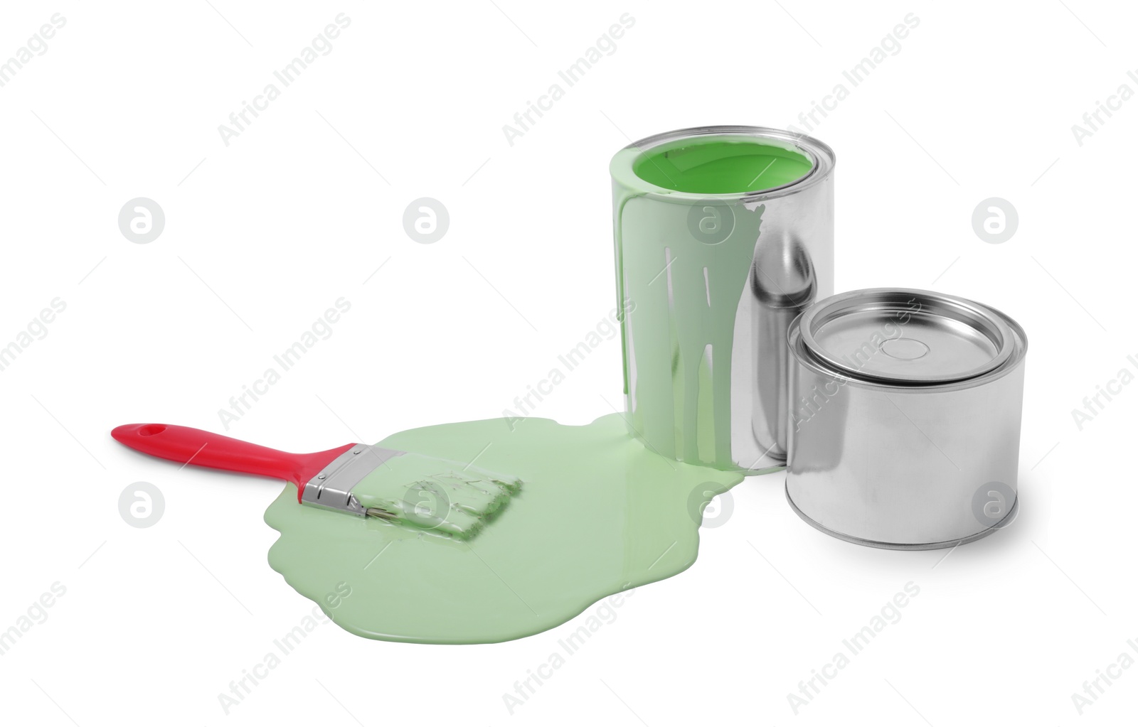 Photo of Spilled light green paint, brush and cans on white background