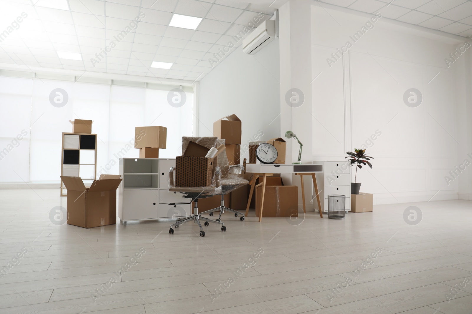 Photo of Cardboard boxes and packed stuff in office. Moving day