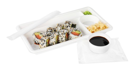 Food delivery. Plastic container with delicious sushi rolls and bowl of soy sauce on white background