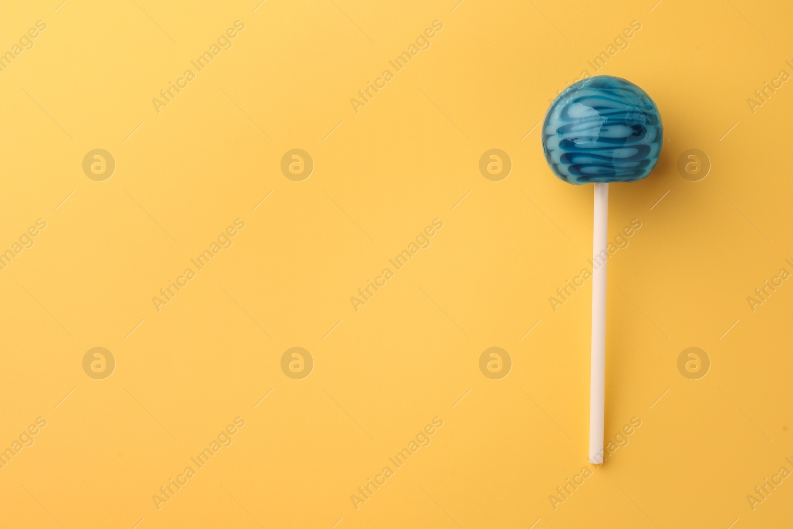 Photo of Tasty lollipop on orange background, top view. Space for text