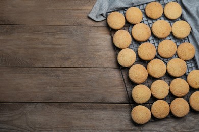 Many tasty sugar cookies on wooden table, top view. Space for text