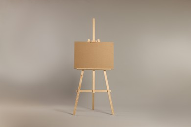Photo of Wooden easel with blank board on grey background