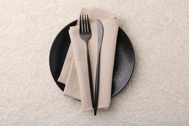 Stylish setting with elegant cutlery on beige textured table, top view